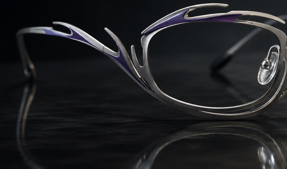 Artistic titanium frame detail on a black reflective surface